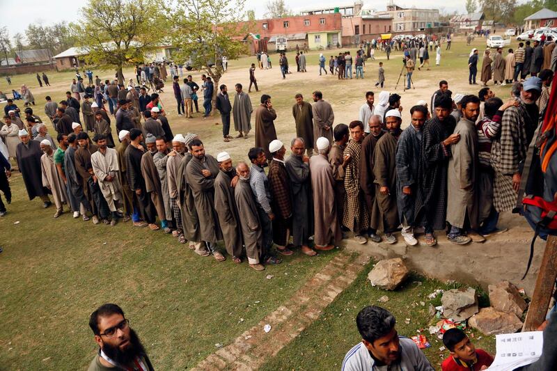 In this April 11, 2019, photo, Kashmiri voters stand in a queue to cast their votes outside a polling station at Shadipora, outskirts of Srinagar, Indian controlled Kashmir. (AP Photo/Mukhtar Khan, File)