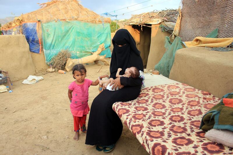 A woman carries a young infant suffering from severe malnutrition since birth in Yemen's northern Hajjah province on December 6, 2020. / AFP / ESSA AHMED
