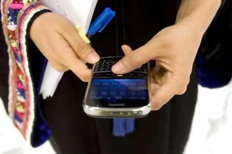 Dubai - July 21, 2009 - A woman uses a Blackberry in the DIFC building in Dubai, July 21, 2009. STOCK (Photo by Jeff Topping/The National) *** Local Caption ***  JT002-0721-BLACKBERRY STOCK 7F8Q2926.jpg