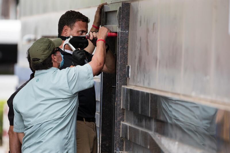 Federal officials and a locksmith work on a door to make entry into the vacated Consulate General of China building. Houston Chronicle via AP