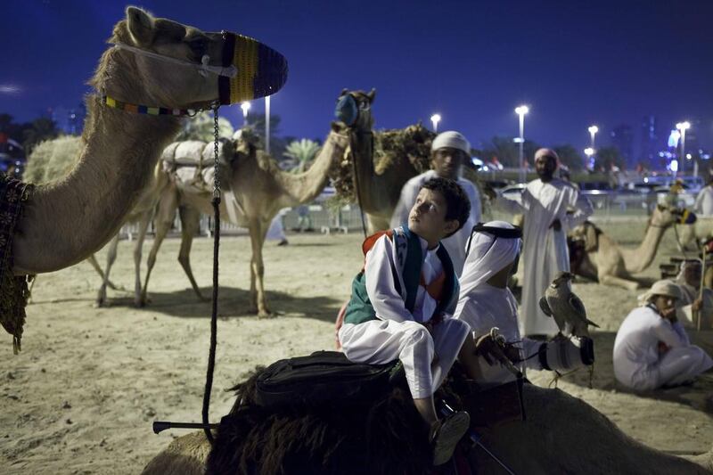 A young Emirati boy sits on a camel while waiting for the 42nd National Day celebrations to begin on Flag Island. Antonie Robertson/The National