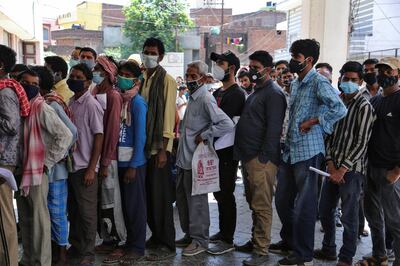 FILE- In this April 19, 2021 file photo, people wearing face masks as a precaution against the coronavirus line up without any physical distancing to get tested for COVID-19 at a government hospital in Jammu, India. India's health system is collapsing under the worst surge in coronavirus infections that it has seen so far. Medical oxygen is scarce. Intensive care units are full. Nearly all ventilators are in use, and the dead are piling up at crematoriums and graveyards. Such tragedies are familiar from surges in other parts of the world ‚Äî but were largely unknown in India. (AP Photo/Channi Anand, File)