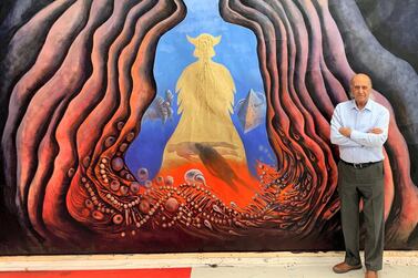 Iraqi artist Ala Bashir standing next to one of his paintings. Courtesy Ala Bashir
