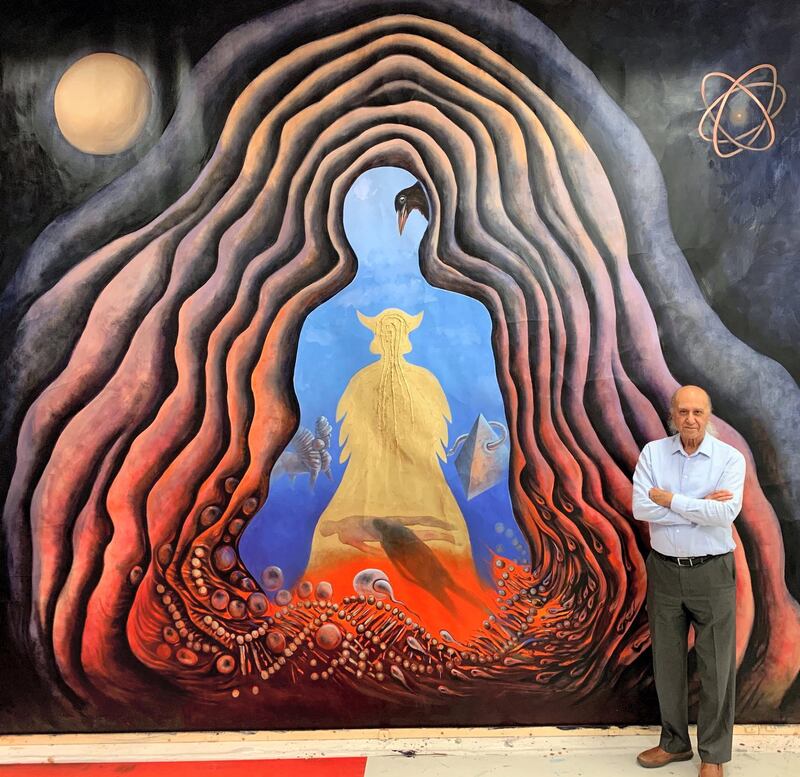 Ala Bashir standing next to one of his paintings. Courtesy Ala Bashir