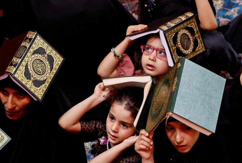 Worshippers with copies of the Quran on their heads
