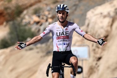 UAE Team Emirates British rider Adam Yates gestures as he crosses the finish line to win the fifth stage and the Tour of Oman cycling race, at Jabal Al Akhdhar (Green Mountain) on February 14, 2024.  (Photo by Anne-Christine POUJOULAT  /  AFP)