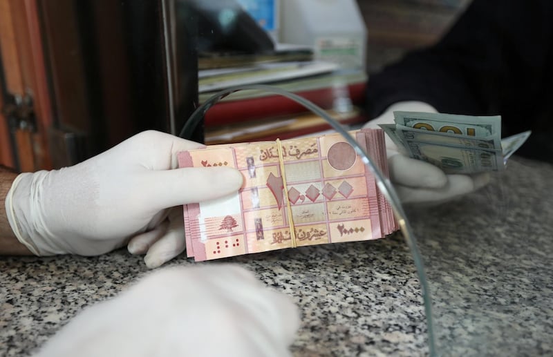 A customer wearing gloves holds Lebanese pounds at a currency exchange store, during a countrywide lockdown to combat the spread of coronavirus disease (COVID-19) in Beirut, Lebanon April 3, 2020. REUTERS/Mohamed Azakir