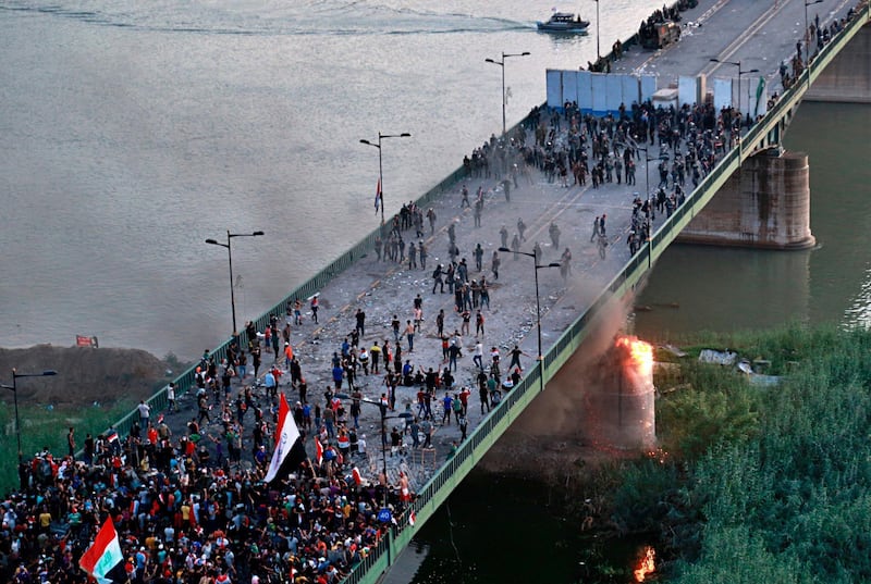 Security forces fire tear gas and close the bridge leading to the Green Zone during a demonstration in Baghdad, Iraq. AP Photo