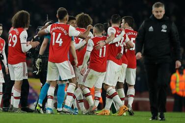 Arsenal players celebrate as Manchester United manager Ole Gunnar Solskjaer walks off at the end of the match. AP