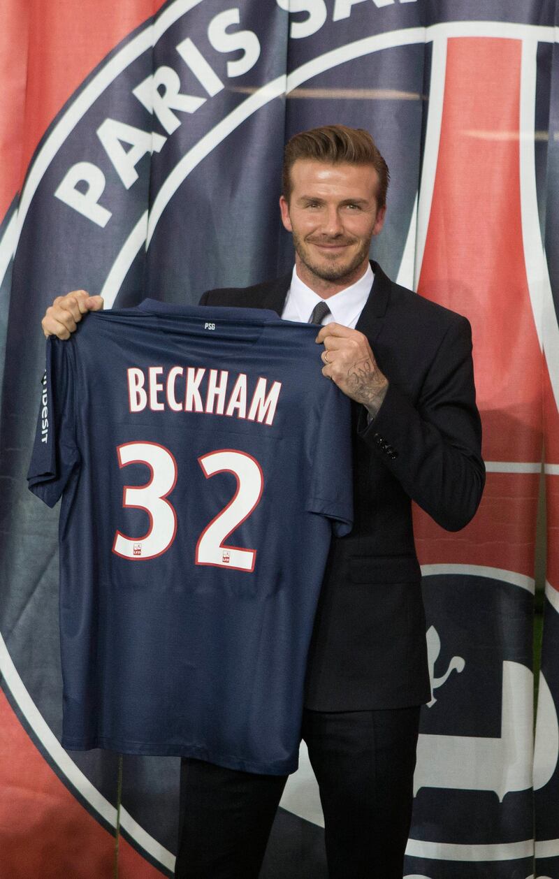 British soccer player David Backham, poses with his new jersey in front of the PSG logo during a press conference, at the Parc des Princes stadium in Paris, Thursday, Jan. 31, 2013. David Beckham will join Paris Saint-Germain on Thursday, opting for a move to France after mulling over lucrative offers from around the world since leaving the Los Angeles Galaxy.(AP Photo/Michel Euler) *** Local Caption ***  France Beckham PSG.JPEG-0c98b.jpg