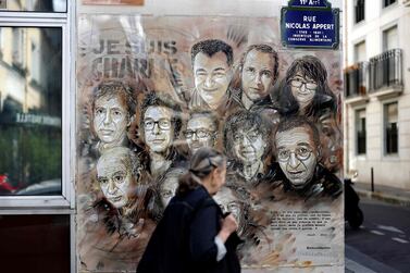 A woman walks past a painting by French street artist and painter Christian Guemy, known as C215, in tribute to members of the magazine ‘Charlie Hebdo’ who were killed by extremist gunmen in Paris in January 2015. AFP