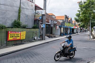 A motorist drives on a nearly empty street in a tourist area of Kuta in Bali, Indonesia. President Joko Widodo is resisting stricter movement curbs that would further dent the region’s biggest economy. Photo: EPA