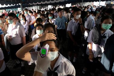 Health officials check students' temperatures as middle school students in Thailand which reported its first death form Covid-19 on Sunday. AP Photo