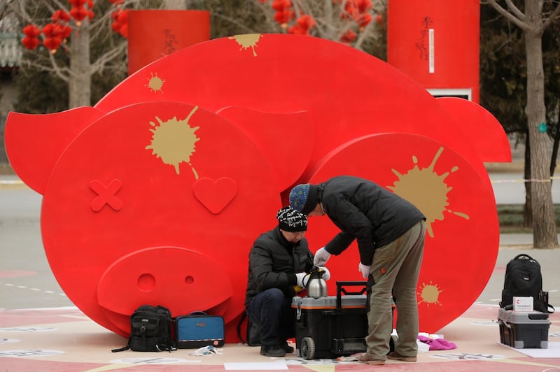 Workers make tea near decorations ahead of the Chinese Lunar New Year at Ditan Park in Beijing. AP Photo