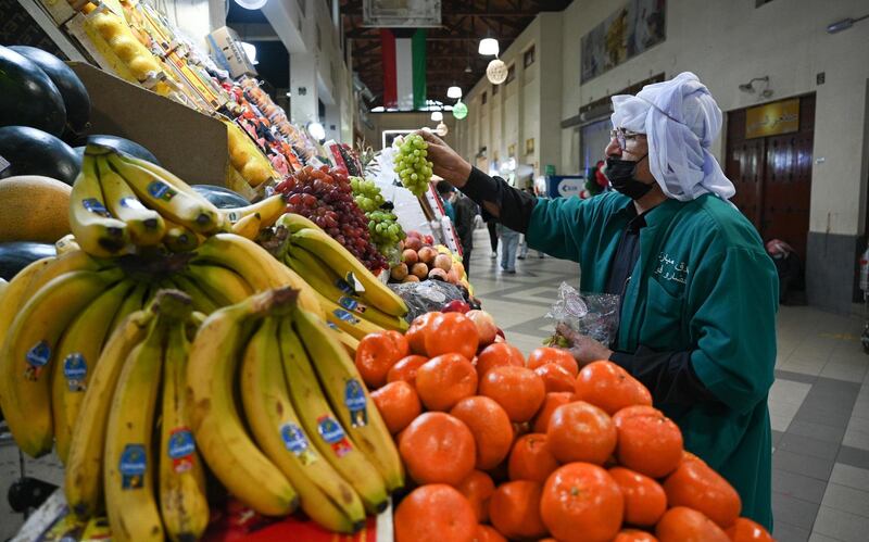 A vendor arranges fruit on display at Kuwait City's Souk Al Mubarakiya. EPA