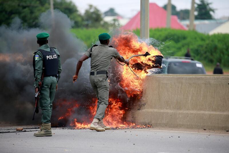 A police officer removes burning tires from the road, as protesters set up fires to block traffic along Airport Road in Abuja, Nigeria September 4, 2019. REUTERS/Afolabi Sotunde TPX IMAGES OF THE DAY
