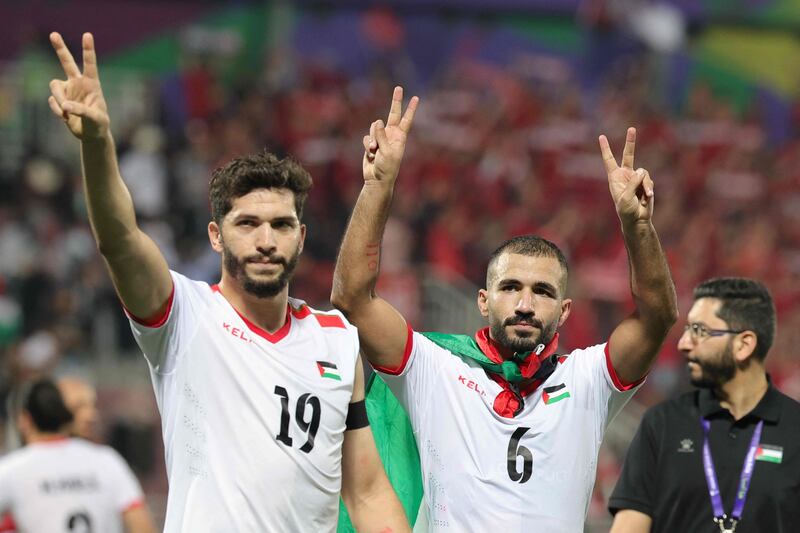 Palestinian players Mahmoud Wadi and Oday Kharoub greet supporters after making history in the Asian Cup in Qatar. AFP