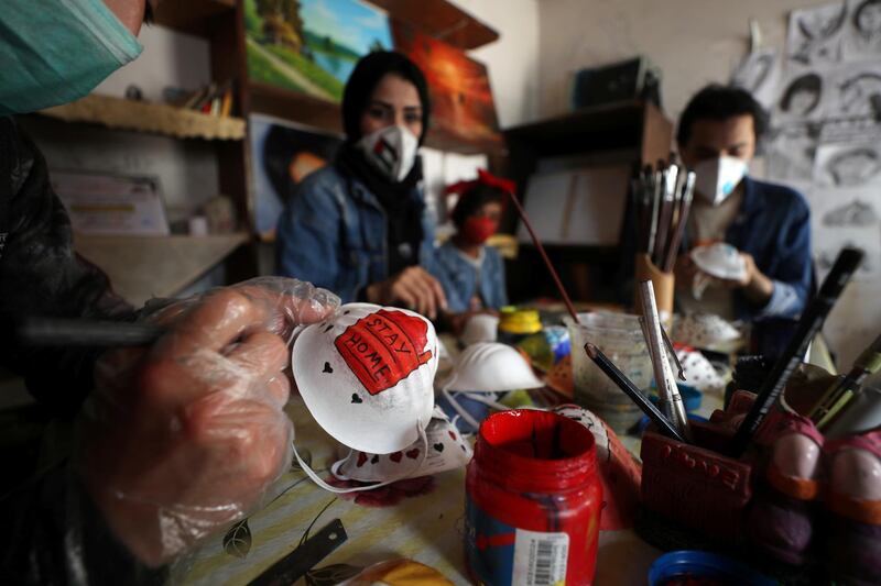 Palestinian artists paint protective face masks to encourage people to wear them as a precaution against the coronavirus disease, in Gaza City. Reuters