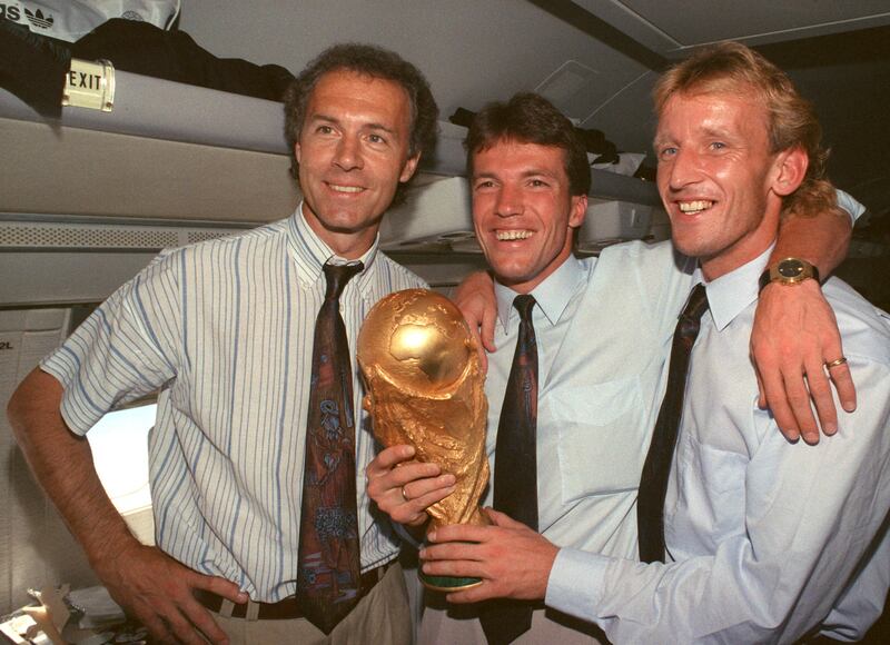 Germany manager Franz Beckenbauer, left, stands with midfielder and captain Lothar Matthaus, centre, and defender Andreas Brehme in the cabin of an airplane with the World Cup trophy in 1990. Getty Images