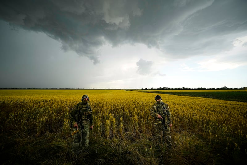 Russian soldiers guard an area next to a field of wheat in the Zaporizhzhia region. AP 