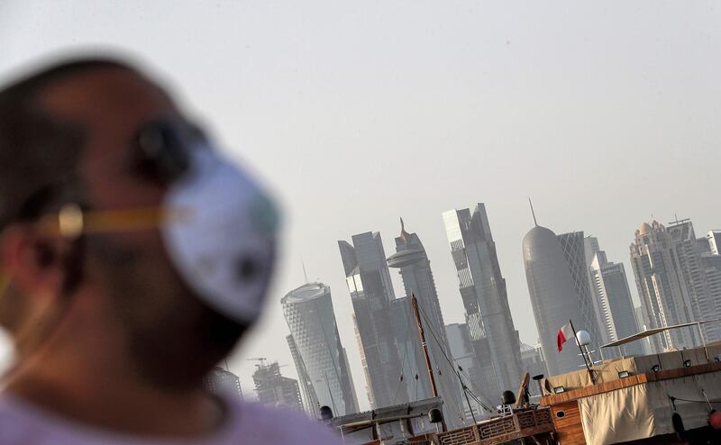 (FILES) In this file photo taken on March 16, 2020 A man wearing a mask as a precaution against COVID-19 coronavirus disease, walks along the Doha corniche in the Qatari capital. Qatar on May 17 began enforcing the world's toughest penalties of up to three-years imprisonment for failing to wear masks in public places as it battled a coronavirus infection rate among the highest globally. - QATAR OUT
 / AFP / - / QATAR OUT
