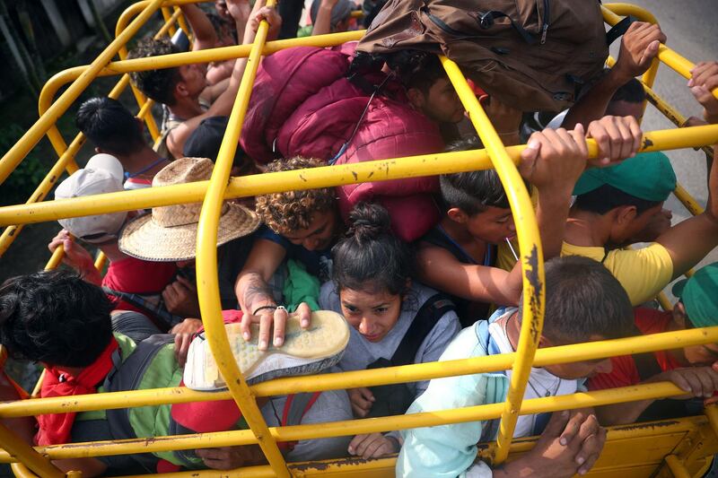 Migrants hitchhike on a truck along the highway to Sayula de Aleman from Donaji, Mexico. Reuters