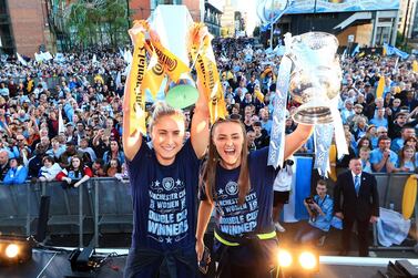 Manchester City's Steph Houghton, left, and Georgia Stanway celebrate with the Women's FA Cup and Continental Cup trophies during the Manchester City Teams Celebration Parade on on May 20, 2019. Getty Images