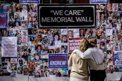 Theresa Sari, left, and her daughter Leila Ali look at a protest-memorial wall for nursing home residents who died from Covid-19, including Ms Sari's mother Maria Sachse, in New York. AP 