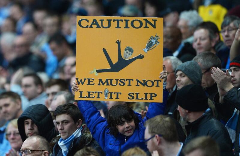 A Manchester City fan holds a message for his team referencing Liverpool captain Steven Gerrard's slip against Chelsea during the Premier League match between Manchester City and Aston Villa at Etihad Stadium on Wednesday. Michael Regan / Getty Images / May 7, 2014