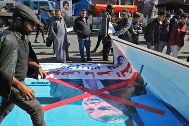 Protesters unfurl Mohammad Allawi's poster on the ground in Baghdad's Tahrir Square on February 3, 2020. AFP