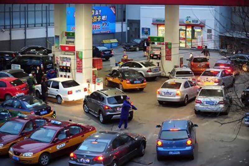 Cars queue up at a Chinese petrol station ahead of the price hike in Beijing. China's continued growth and the resulting thirst for oil will be a boon for Arabian Gulf oil producers, including the UAE. AFP
