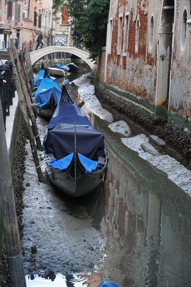 Gondolas lay idle as they sit on the muddy bed of a canal in the San Marco district of Venice, Italy, on February 25, 2021. EPA