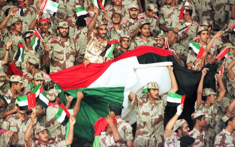Emirati solders celebrating 10 December the victory of their team against Indonesia during an Asian Cup match in Al Ain stadium. UAE defeated Indonesia 2-0 and qualified for the quarter-finals. (Photo by RAMZI HAIDAR / AFP)