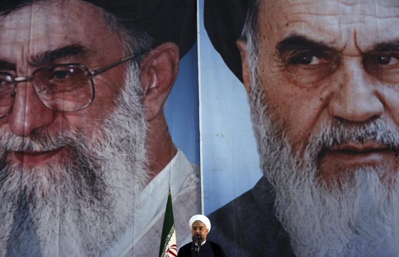 Iranian President Hassan Rouhani makes an address in front of portraits of the supreme leader Ayatollah Ali Khamenei, left, and Ayatollah Khomeini, the founder of the Islamic Republic during a ceremony marking his 25th death anniversary at his shrine just outside Tehran. Vahid Salemi / AP Photo