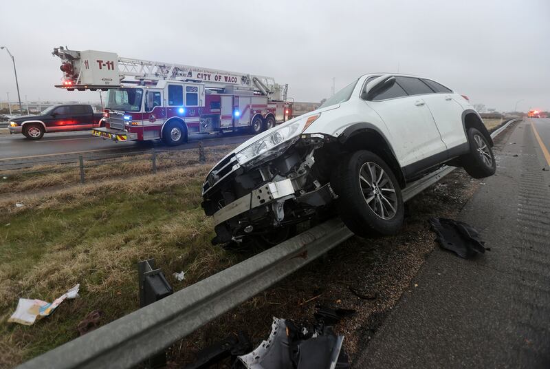 A vehicle rests on a barricade after the driver lost control and slid off Highway 6 on Tuesday in Waco, Texas. Waco Tribune-Herald / AP