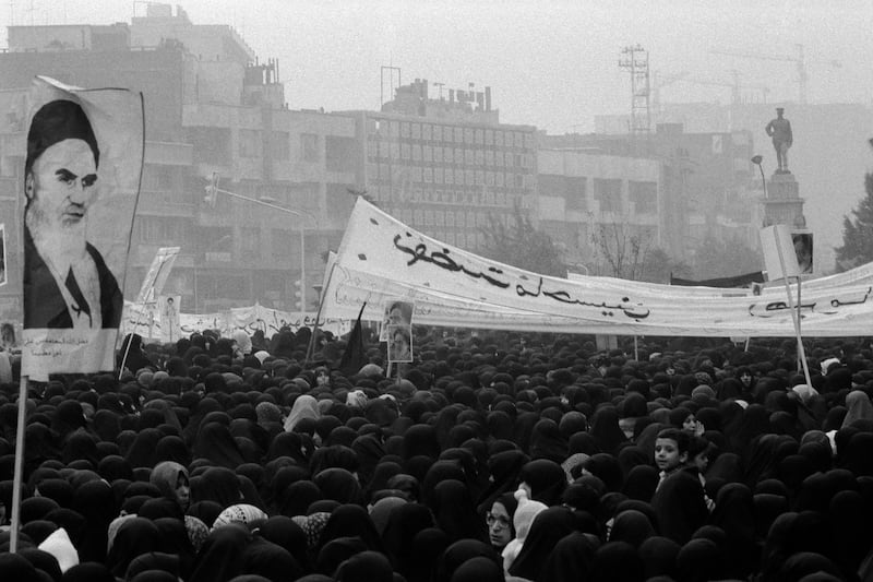 Women demonstrators, carrying posters of Ayatollah Khomeini, gather around a statue of the ruling Mohammad Reza Pahlavi at 24 Esfand square, now known as Revolution Square, 11th December 1978. People held almost daily demonstrations in Tehran at the height of the Iranian Revolution, which eventually led to the overthrow of the Shah by Khomeini, who led the revolution from exile in Paris. (Photo by Kaveh Kazemi/Getty Images)