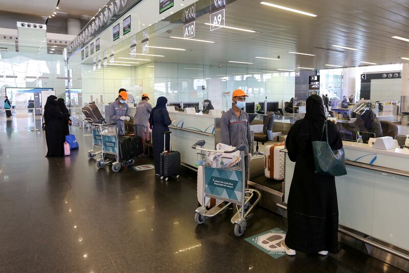 Passengers talk to airline employees at Riyadh International Airport, after Saudi Arabia reopened domestic flights in May 2020. Reuters