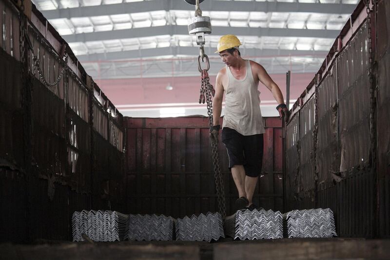 FILE PHOTO: A worker helps load steel bars onto a truck at warehouse of the Baifeng Iron and Steel Corporation in Tangshan, Hebei province, China August 3, 2015. REUTERS/Damir Sagolj/File Photo