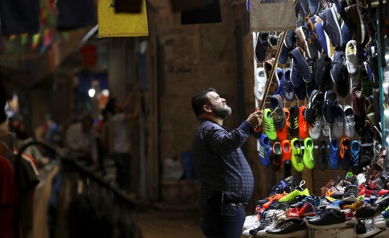 epa06171236 A Palestinian vendor waits to sell shoes ahead of the Eid al-Adha festival, in the West Bank city of Nablus, 30 August 2017. Eid al-Adha is the holiest of the two Muslims holidays celebrated each year, it marks the yearly Muslim pilgrimage (Hajj) to visit Mecca, the holiest place in Islam. Muslims slaughter a sacrificial animal and split the meat into three parts, one for the family, one for friends and relatives, and one for the poor and needy.  EPA/ALAA BADARNEH