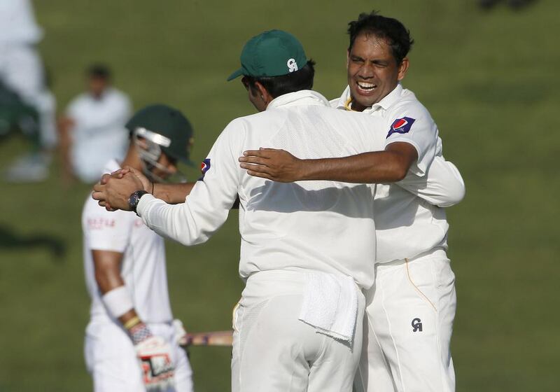 Zulifqar Babar, right, of Pakistan celebrates with a teammate during their first Test against South Africa at the Sheikh Zayed Cricket Stadium in Abu Dhabi on Monday. Karim Sahib / AFP
