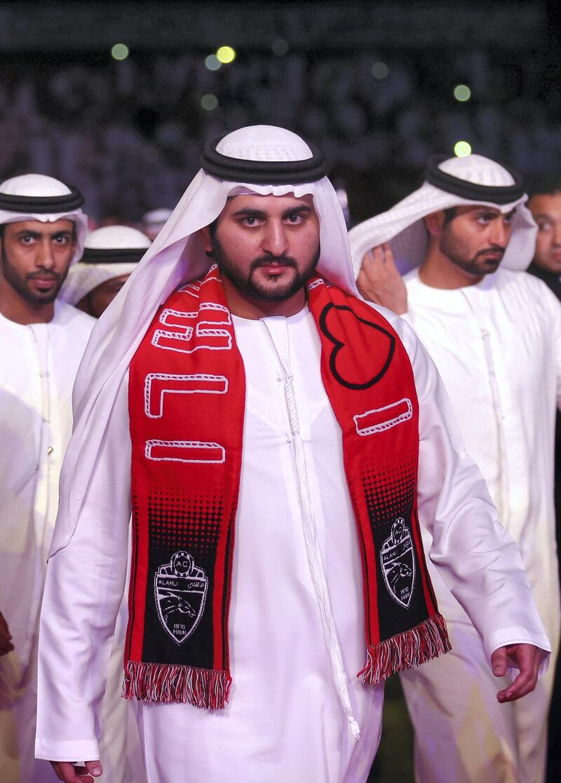 DUBAI, UNITED ARAB EMIRATES - MAY 11:  His Highness Sheikh Maktoum Bin Mohammed Bin Rashid Al Maktoum sports a Al Ahli scarf as he prepares to present the trophy to Al Ahli after the Arabian Gulf football league match between Al Ahil and Al Dhafra at Rashid Stadium on May 11, 2014 in Dubai, United Arab Emirates.  (Photo by Warren Little/Getty Images)