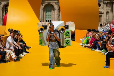 The Louis Vuitton men's spring/summer 2023 show features a bright yellow runway, a blown-up toy racetrack that winds around a cobblestone courtyard. AP Photo
