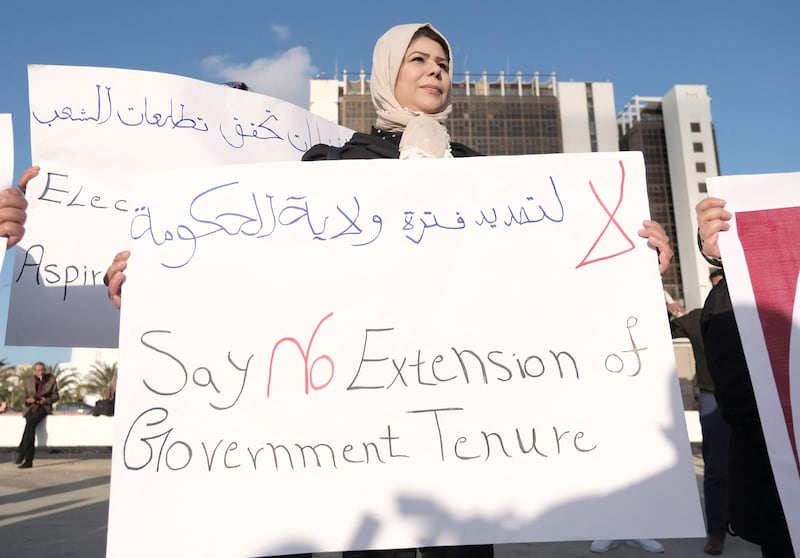 A woman holds a banner during a protest against the delay to the Libyan presidential election, in Benghazi, Libya, on December 24, 2021. Reuters
