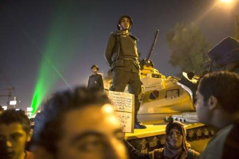 Egyptian soldiers stand guard as protesters opposing president Mohammed Morsi gather during a demonstration at the presidential palace in Cairo.