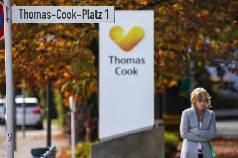 epa07868329 A woman passes next to the logo of the travel company Thomas Cook and a street sign in front of the headquarters of the German branch of Thomas Cook in Oberursel, Germany, 25 September 2019. British Thomas Cook's German tour operator has filed for insolvency on 25 September.  EPA/ARMANDO BABANI