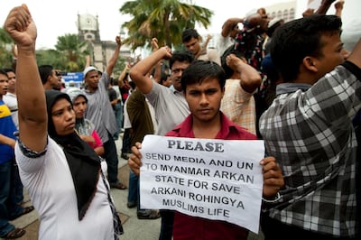 A Myanmar's ethnic Rohingya Muslim displays a placard during a protest outside the national mosque in Kuala Lumpur on June 17, 2012. Rohingya living in Malaysia protested against the deadly religious riots in Myanmar's Arakan state and demanded the United Nations' intervention to restore peace following clashes between Buddhist Rakhine and the Muslim Rohingya that have left dozens dead and more than 30,000 displaced. AFP PHOTO / Mohd RASFAN / AFP PHOTO / MOHD RASFAN