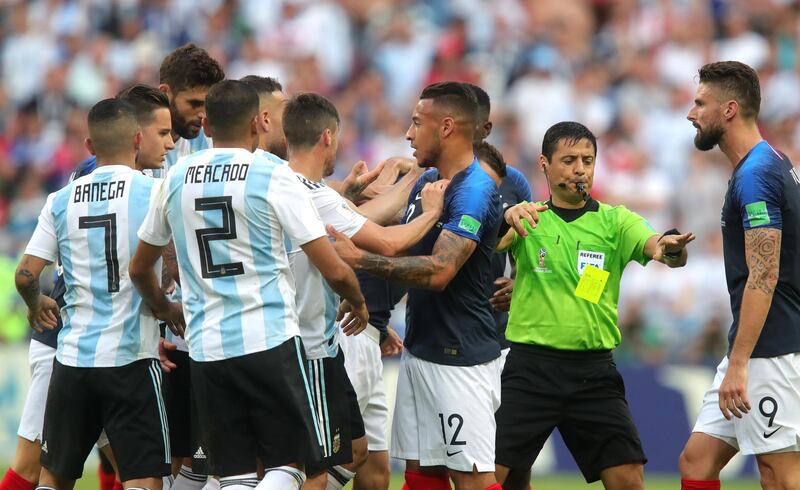 Match referee Alireza Faghani separates players as Corentin Tolisso of France confronts Argentina players. Alexander Hassenstein / Getty Images