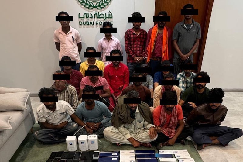Detained fraud suspects shown with seized assets. Photo: Dubai Police