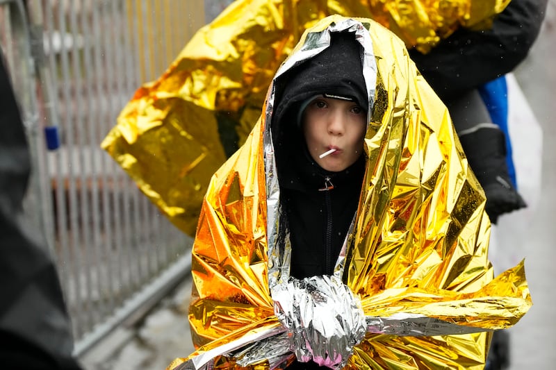 A child wrapped in a rescue emergency blanket crosses the border into Medyka, south-eastern Poland. AP Photo