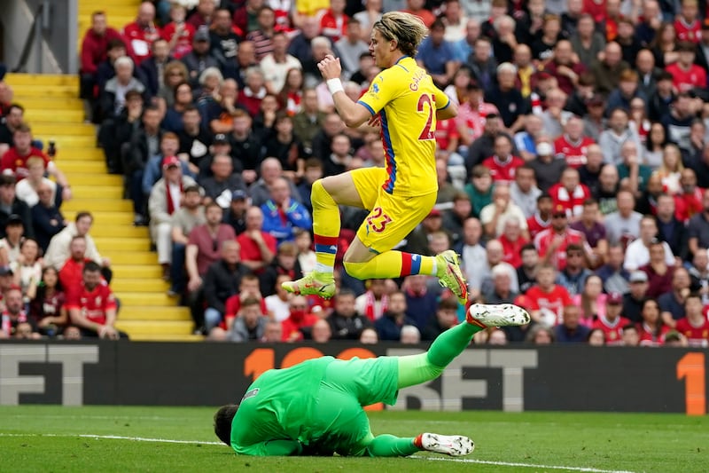 Conor Gallagher leaps over Liverpool goalkeeper Alisson. AP